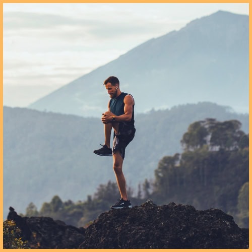 Man standing on top of mountain stretching