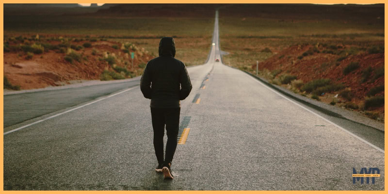 lone man walking down an empty road